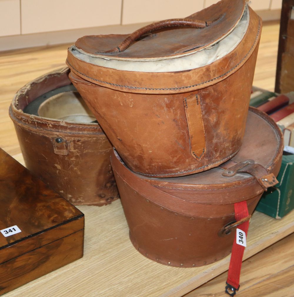 Three silk top hats and leather hat boxes